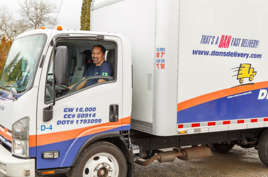 Revive I-5 Ship Canal Bridge 2026: Navigating Seattle Lane Reductions and Spring Load Restrictions Dan's Delivery employee sitting in one of their trucks smiling