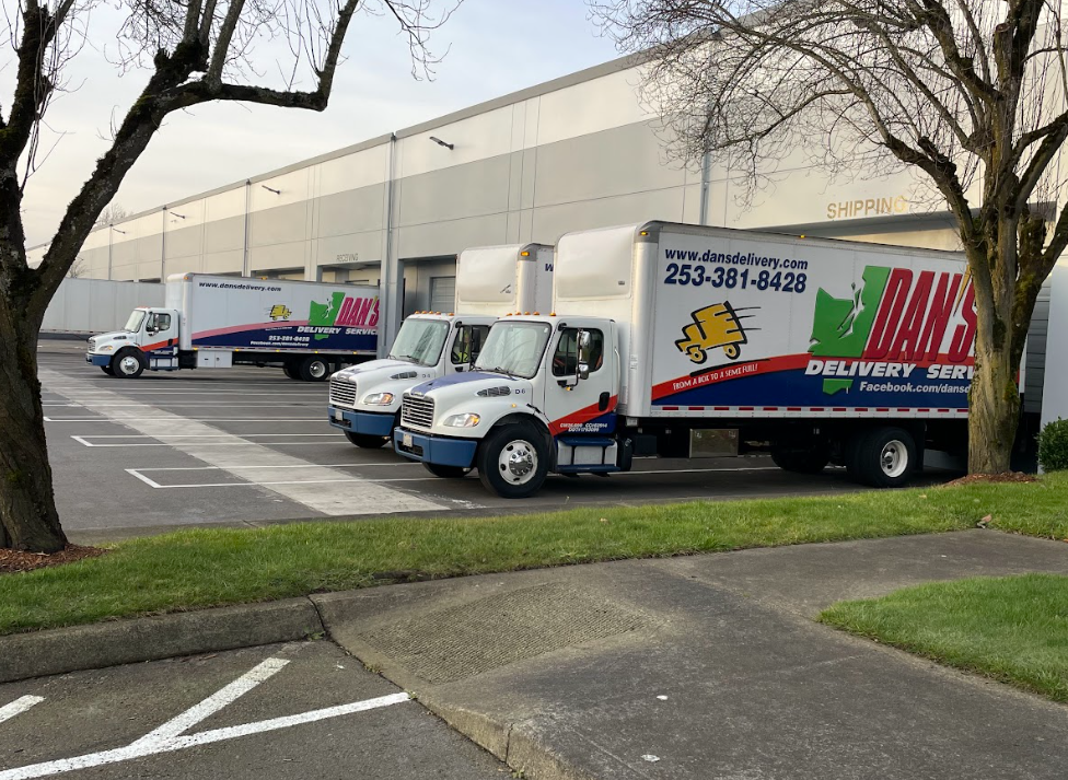 Countering the 2026 Cargo Theft Surge: The Security Benefits of No-Transload Shipping A fleet of Dan's Delivery Trucks backed into a warehouse loading dock