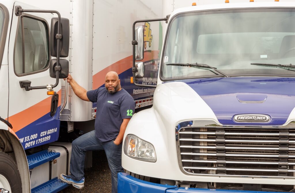 Perfecting the Last Mile: August E-Commerce Ramping for Local Delivery Trucking man standing outside of a delivery truck with his hand on the door | local delivery trucking