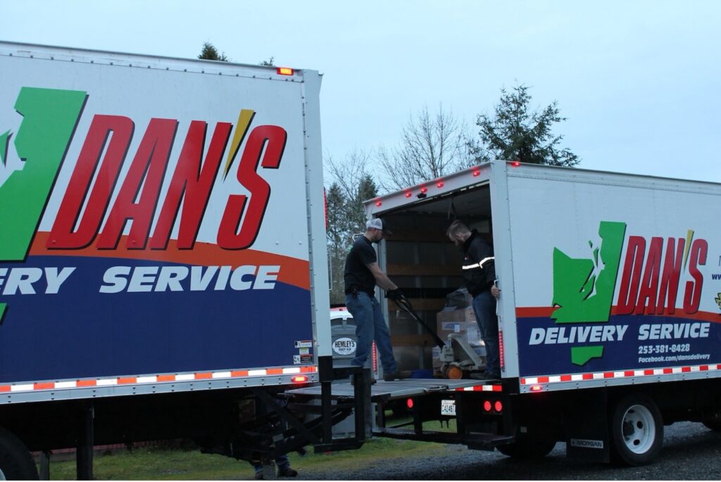 Why Smart Companies Book Freight Capacity Before Thanksgiving two workers transporting boxes from one truck to another | freight capacity