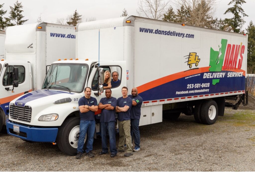 Freight Consolidation vs. Dedicated Delivery: Which Saves More Money for Washington Businesses? Dan's delivery team posing by one of their trucks | freight consolidation